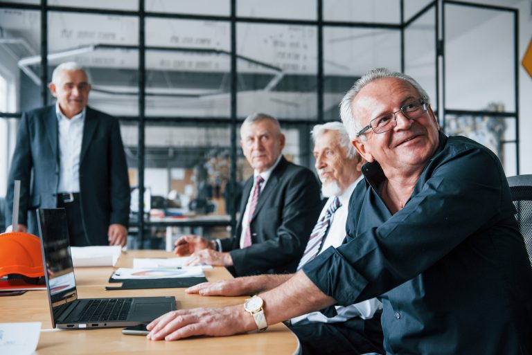 Aged team of elderly businessman architects have a meeting in the office