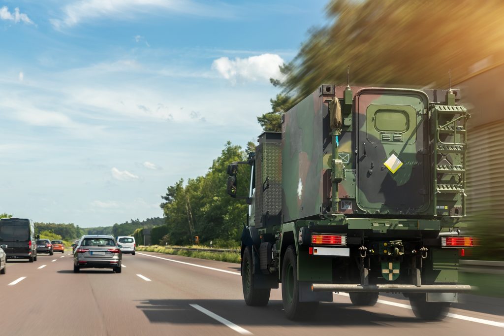 German armoured semi-trailer cargo truck carrier drives military convoy highway road. ALLIANCE