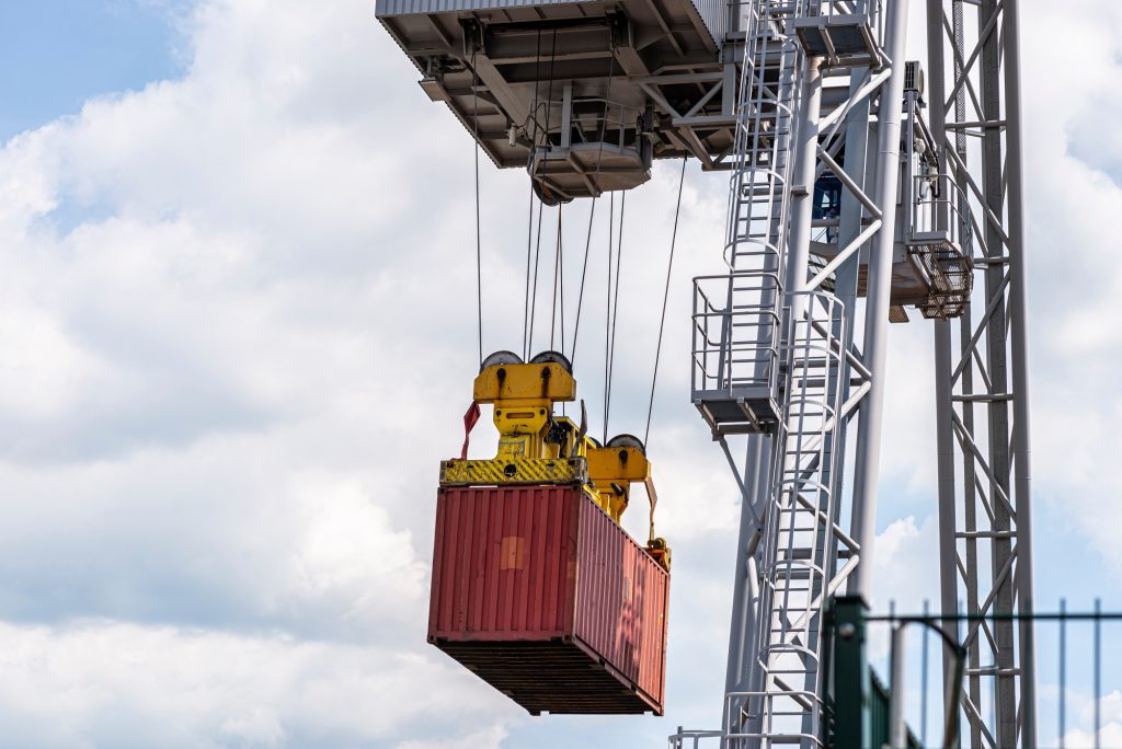 A container gantry crane on a rail loads the container into a barge