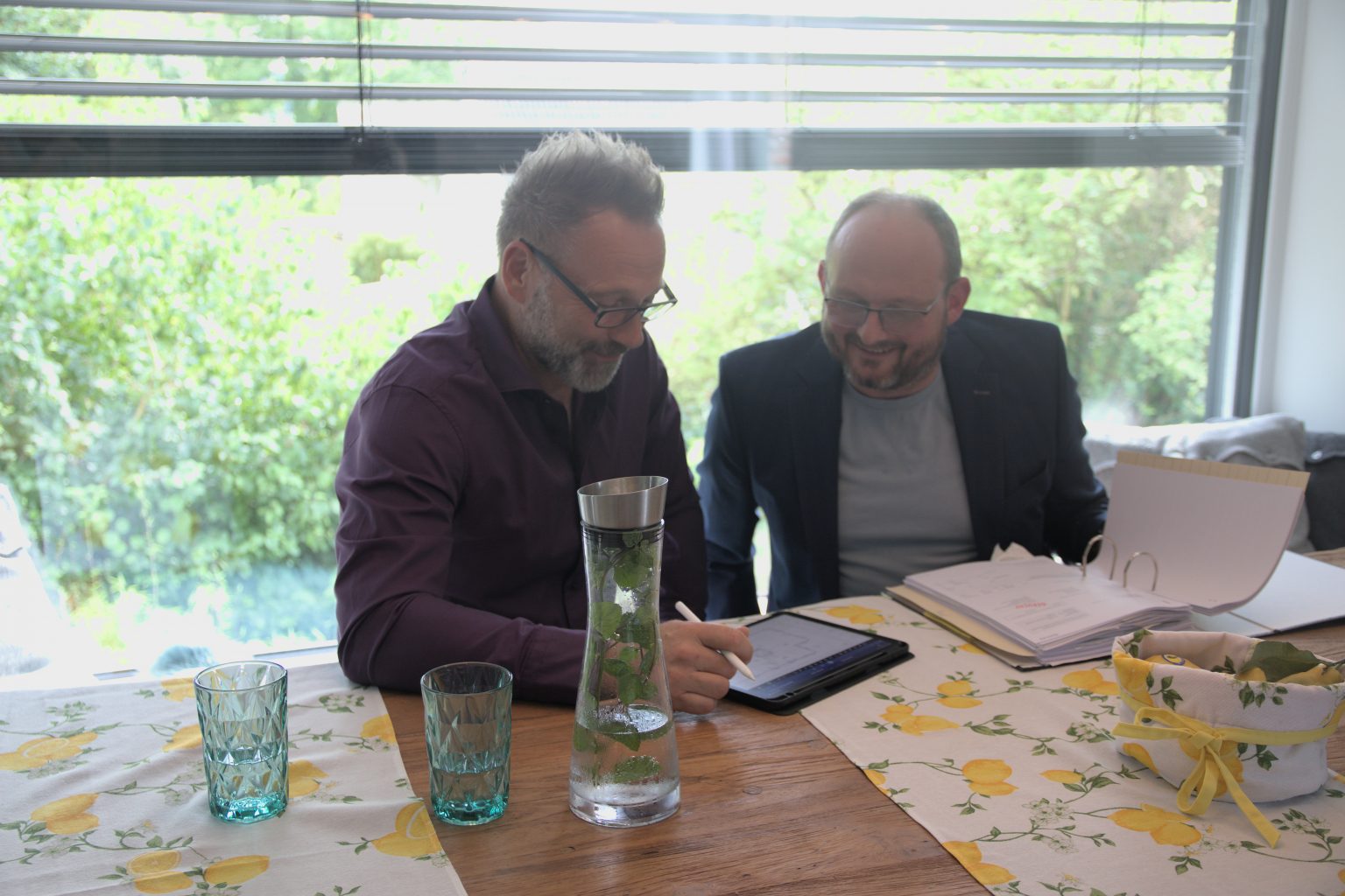 Christoph te Heesen und ein Mandant besprechen Belege am Tablet