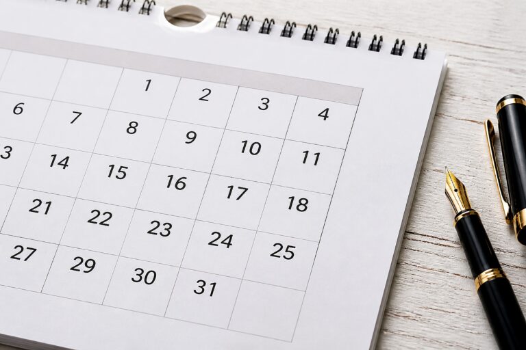 Wandkalender und Füllhalter auf einem Schreibtisch